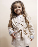 Gabardina de niña beige con cinturón y puños de flores.